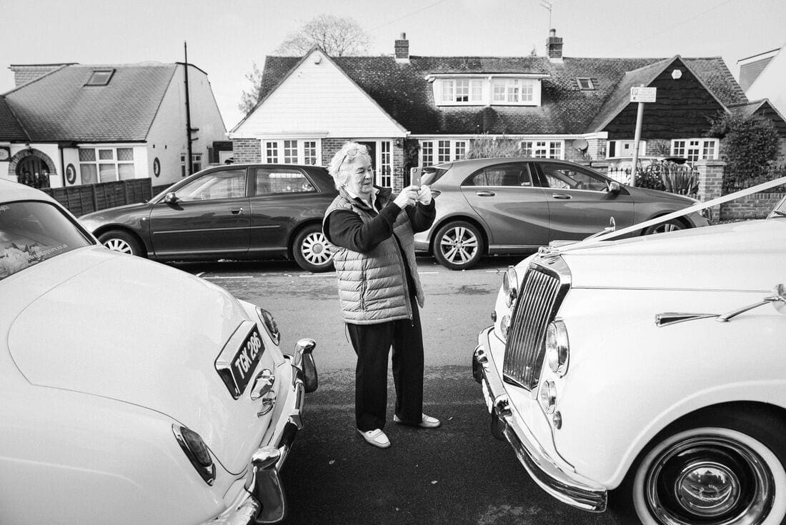 a neighbour gets a photo as the bride leaves for her wedding at micklefield hall