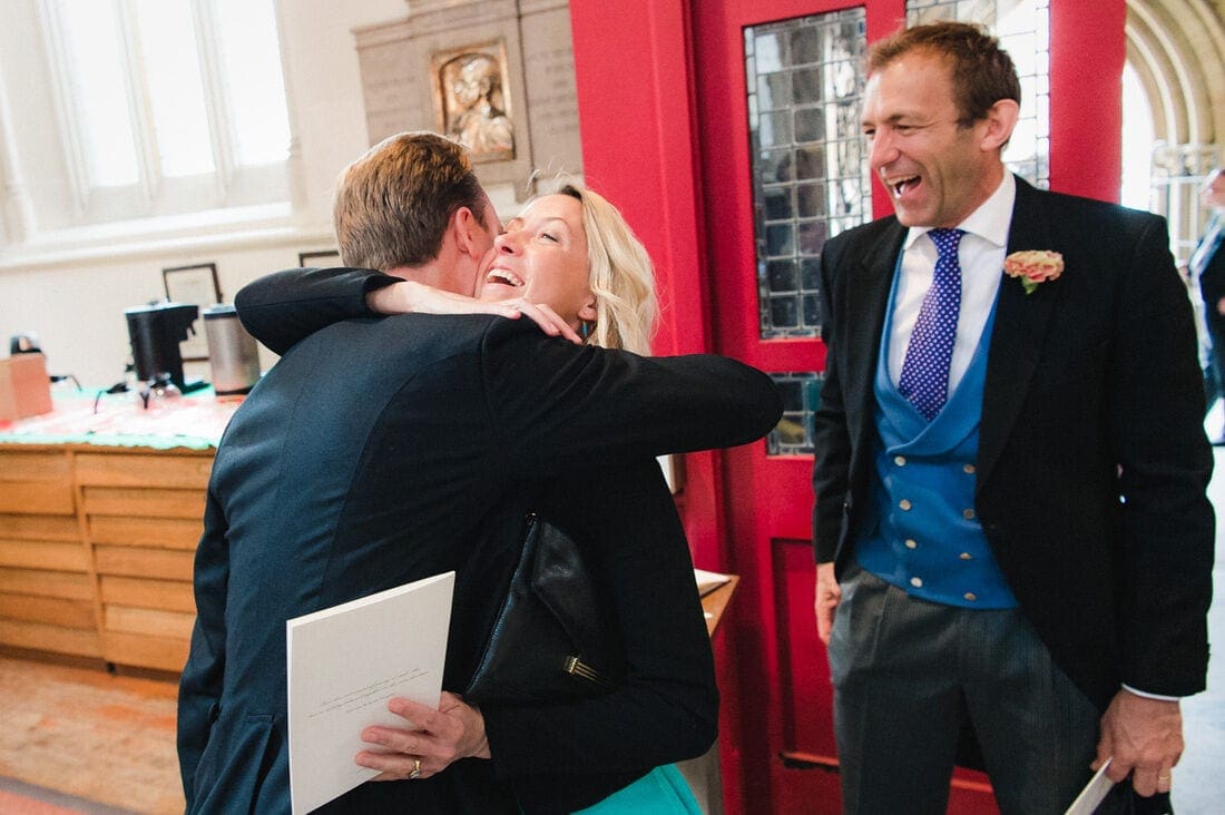 wedding guests greeting the groom with a hug