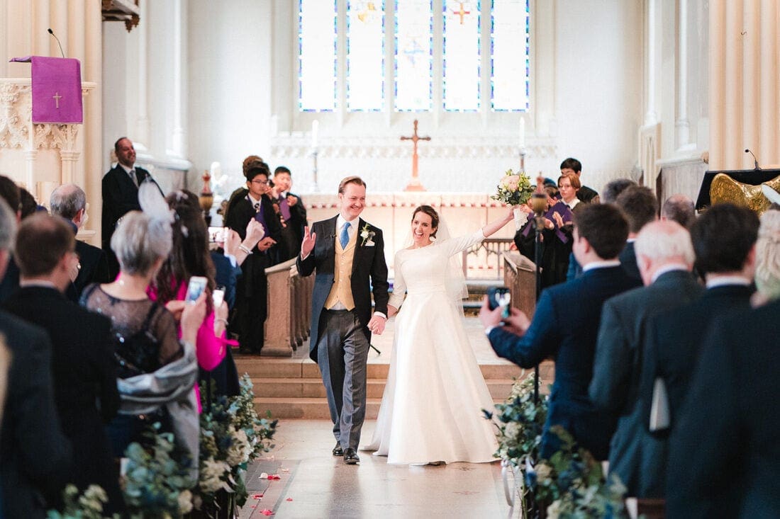 bride and groom celebrate as they walk down the aisle together