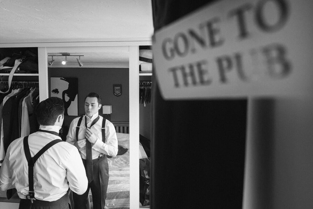 the groom getting ready for the ceremony at home