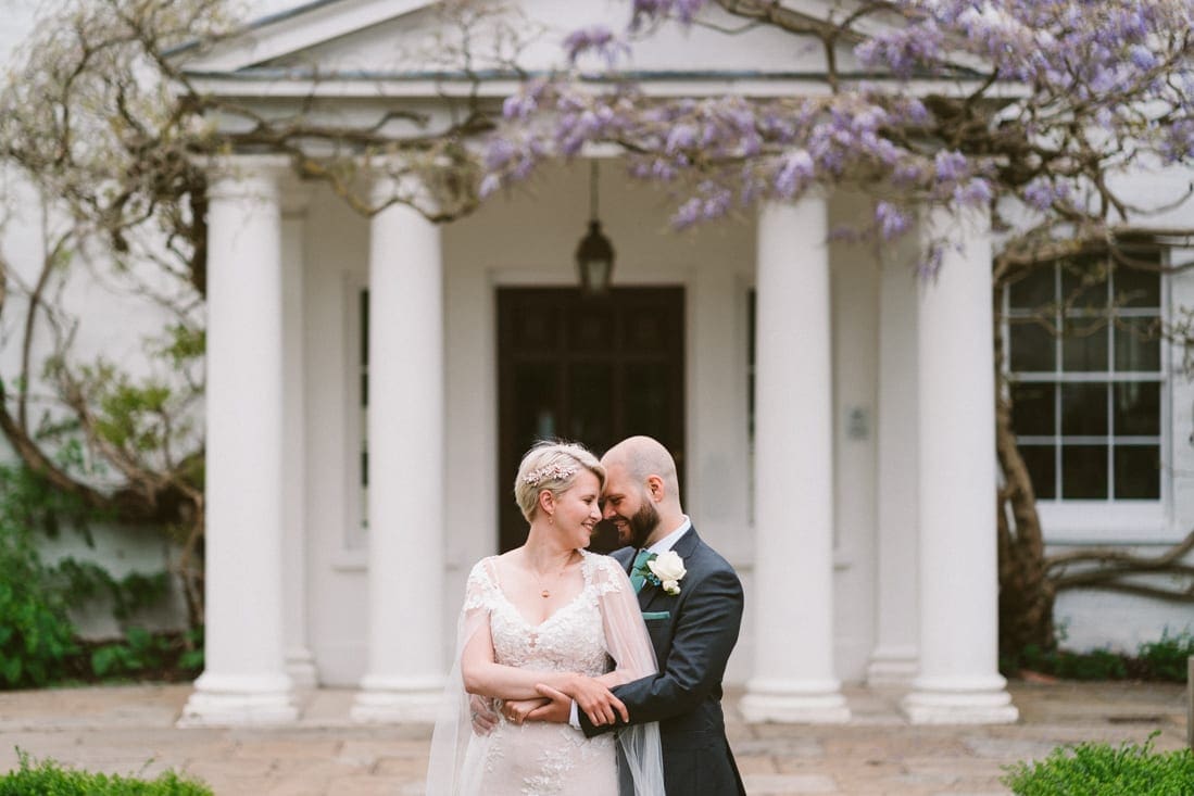 a portrait as husband and wife in front of the Wisteria at Pembroke Lodge